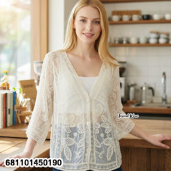 Mannequin wearing cream and white wholesale bohemian lace cardigan with straw hat in a Bangkok showroom.