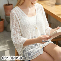 Mannequin wearing cream and white wholesale bohemian lace cardigan with straw hat in a Bangkok showroom.