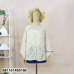 Mannequin wearing cream and white wholesale bohemian lace cardigan with straw hat in a Bangkok showroom.