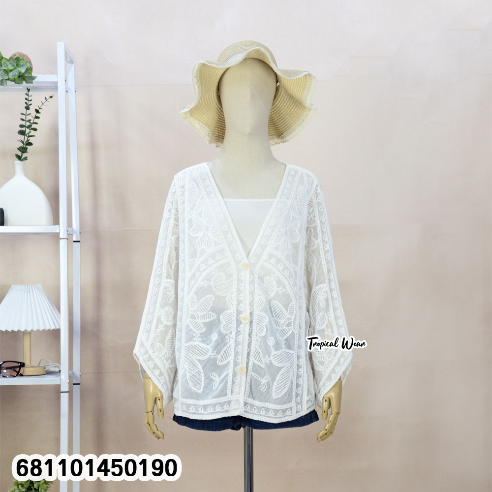 Mannequin wearing cream and white wholesale bohemian lace cardigan with straw hat in a Bangkok showroom.