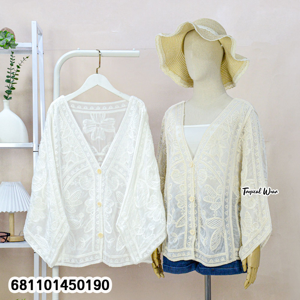 Mannequin wearing cream and white wholesale bohemian lace cardigan with straw hat in a Bangkok showroom.