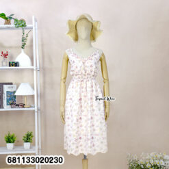 Floral pastel midi dress with elastic waist worn at beach setting, lightweight summer resort style.