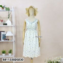 Floral pastel midi dress with elastic waist worn at beach setting, lightweight summer resort style.