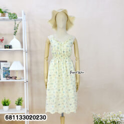 Floral pastel midi dress with elastic waist worn at beach setting, lightweight summer resort style.