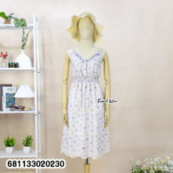 Floral pastel midi dress with elastic waist worn at beach setting, lightweight summer resort style.